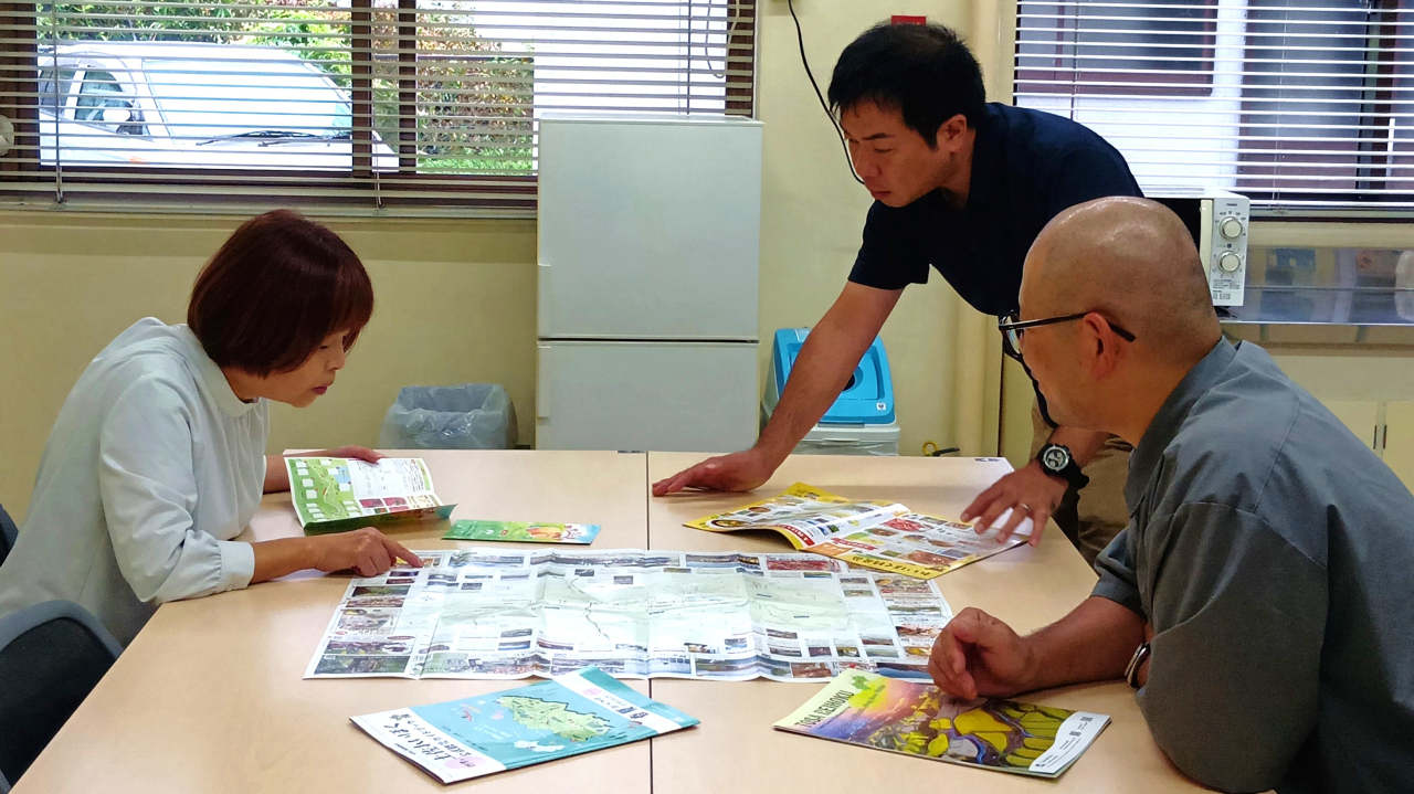 地域の方と資料を広げながら観光商品について打ち合わせる様子